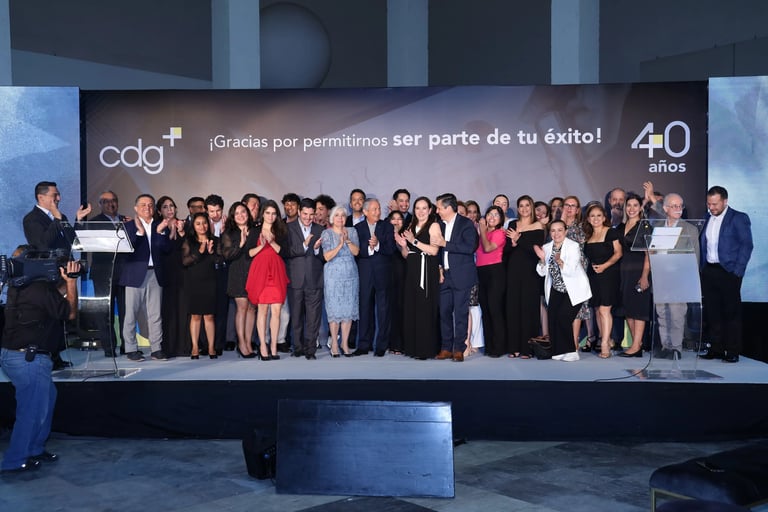 Equipo de cdg celebrando 40 años de trayectoria y éxito junto a colaboradores en un evento corporativo.