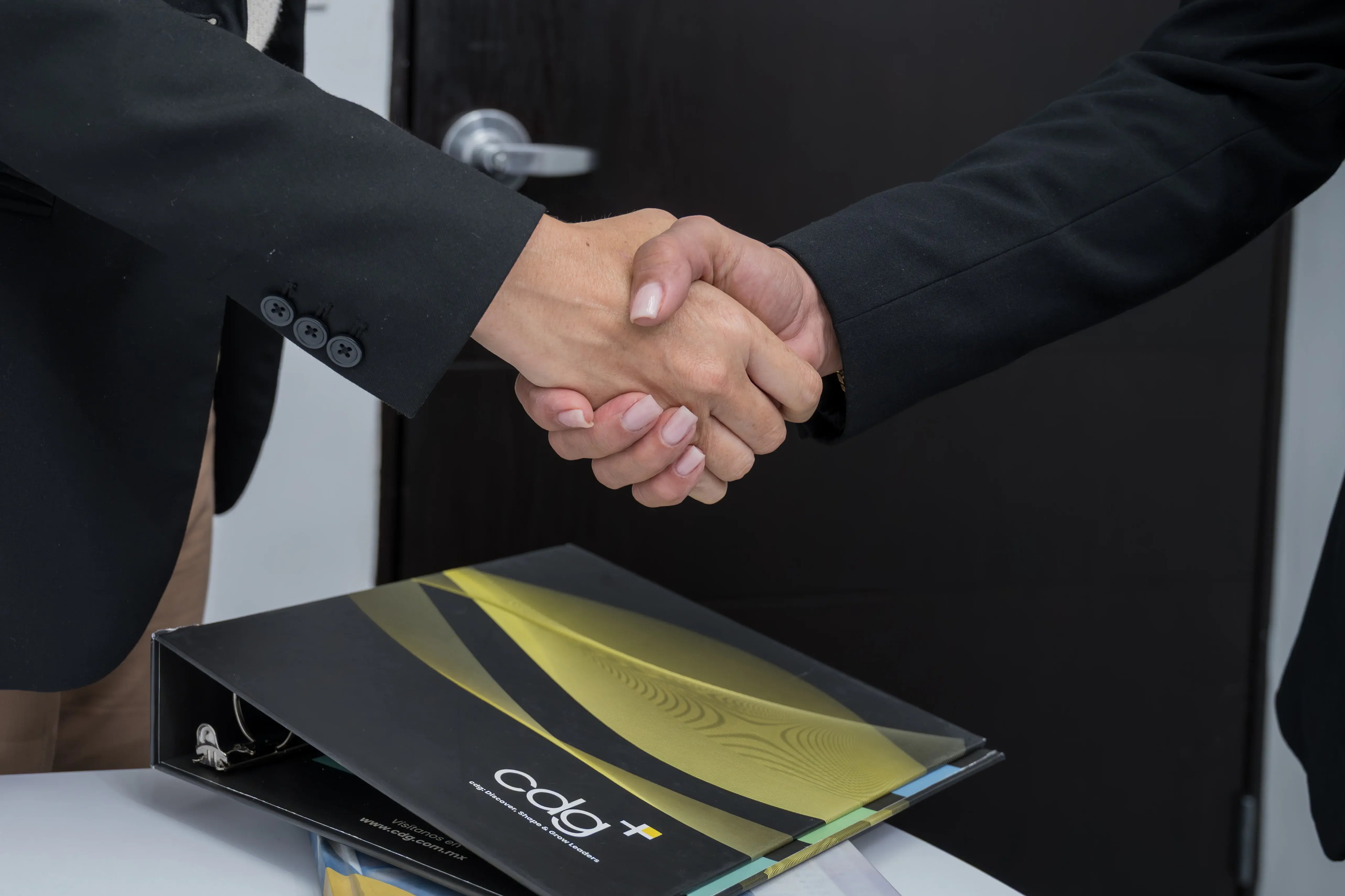 Profesionales estrechando las manos para formalizar una colaboración en un entorno corporativo