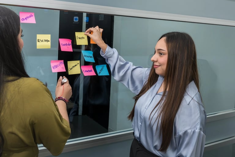 Profesionales colaborando en una sesión de trabajo con notas adhesivas para desarrollar estrategias de talento