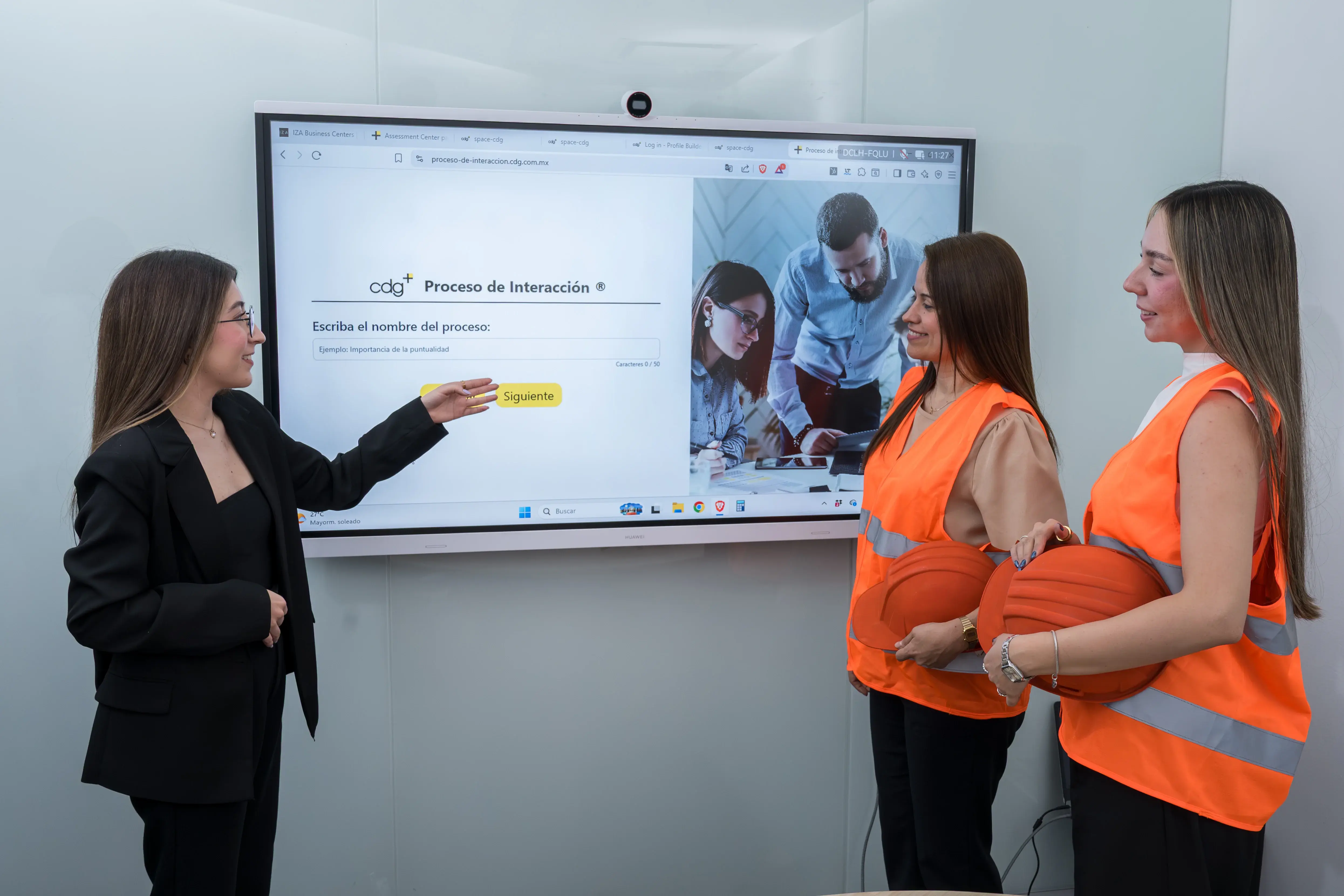 Profesional capacitando a colaboradoras en un proceso de trabajo y seguridad laboral en un entorno corporativo